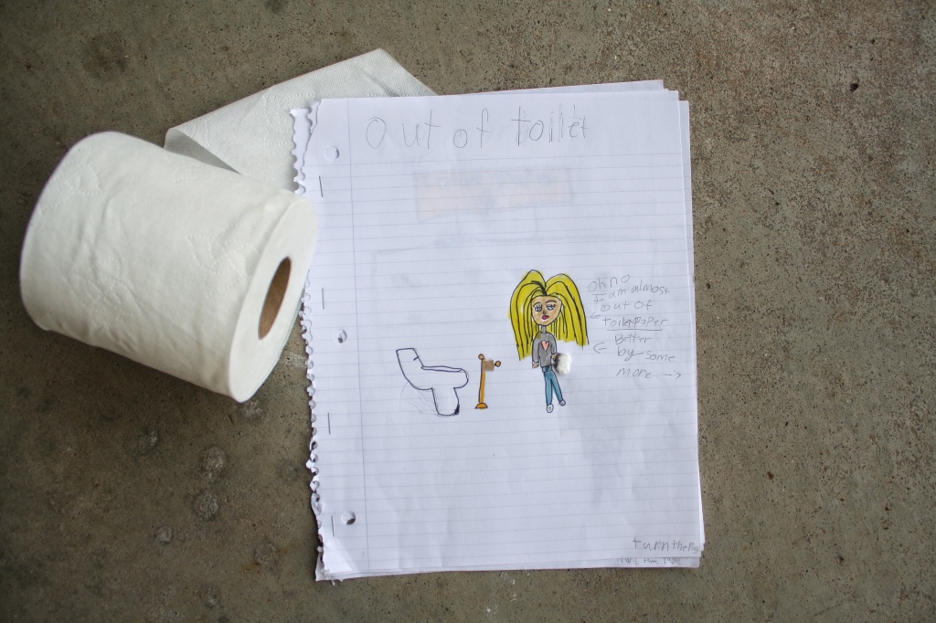 A roll of toilet paper next to a piece of looseleaf oapre with a children's story about a toilet paper fairy drawn by the children of Katie Dunlavy, Lularoe boutique owner, of The Pearl Pages